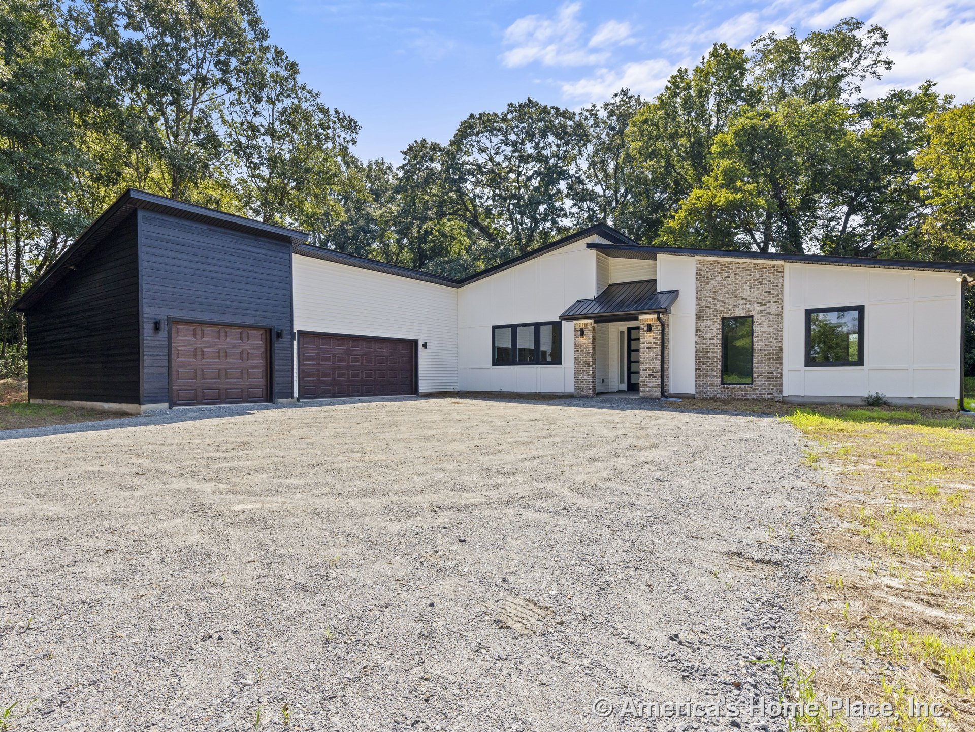 Modern single-story home with dark horizontal and light vertical siding, brick entry wall, three black-trimmed garage doors, covered front porch, large black-framed windows, entry