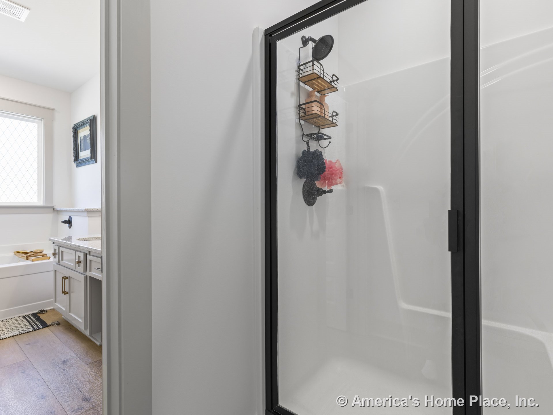 Glass-enclosed shower and built-in bathtub with white cabinetry, granite countertops, wood flooring, and a window with grid pattern.