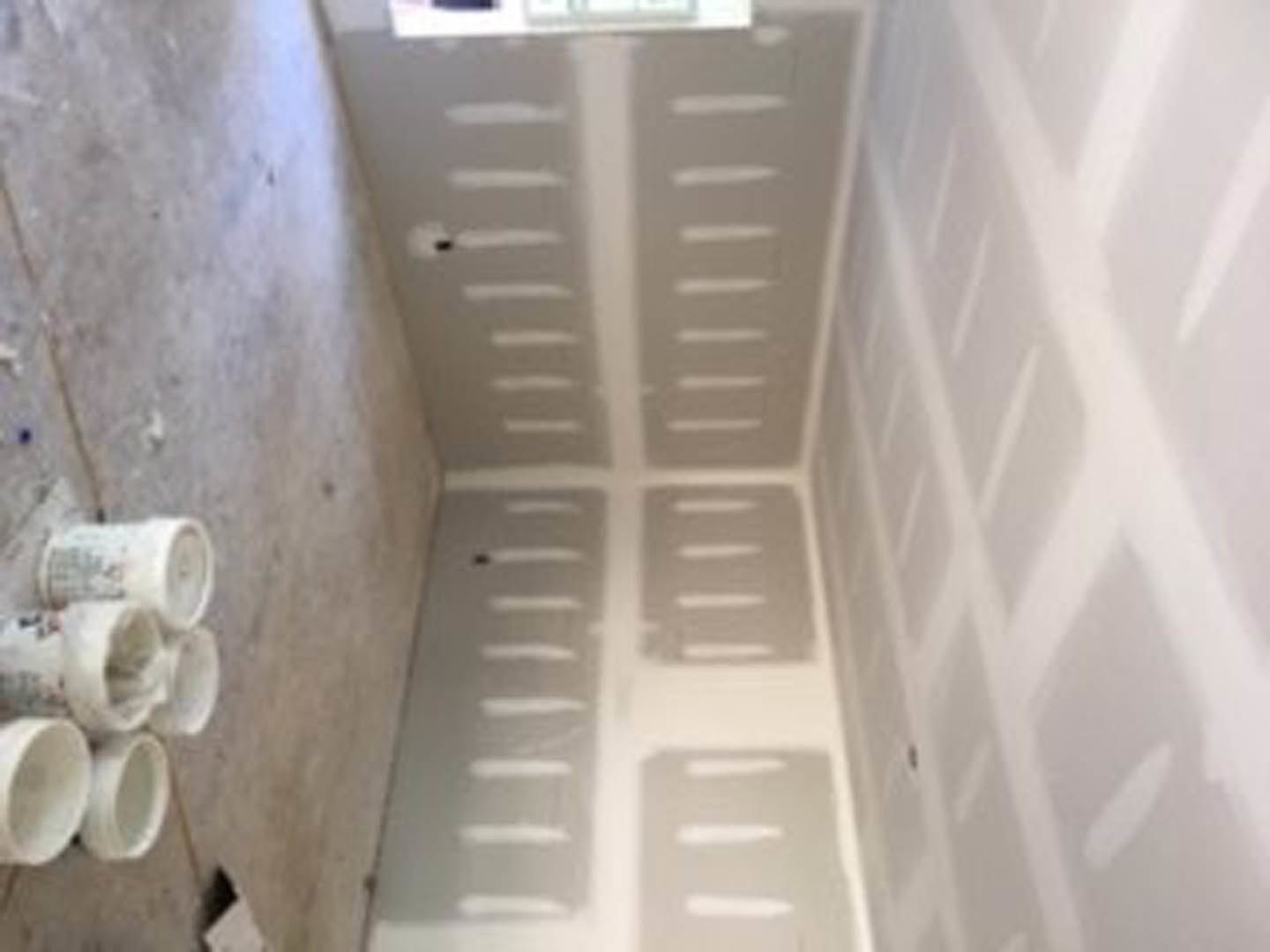 Bathroom with white plaster walls, marble shower, decorative molding, and white painted finishes