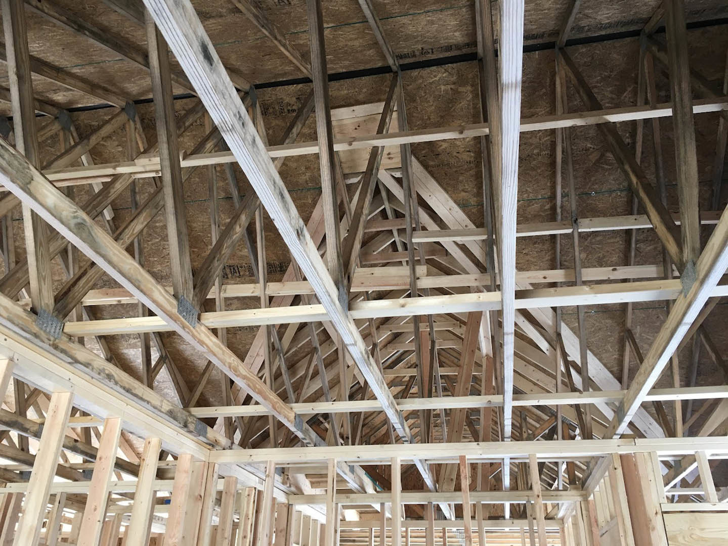 Exposed wooden beams and framing inside a partially constructed residential home