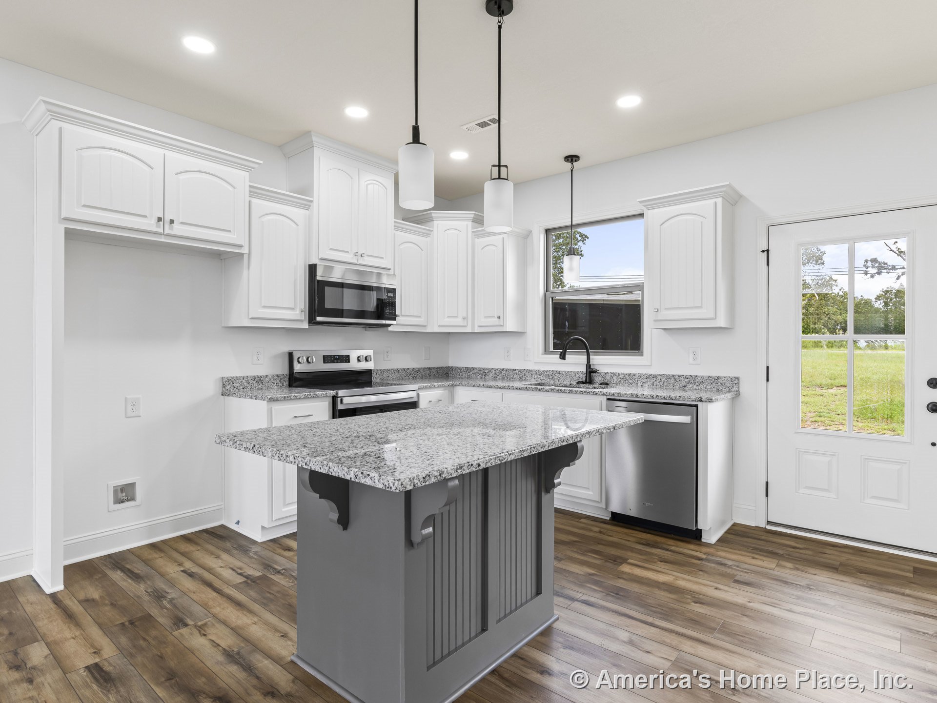Granite kitchen island with white upper and lower cabinets, stainless steel dishwasher, built-in microwave above stove, pendant and recessed lighting, wood-look flooring, window