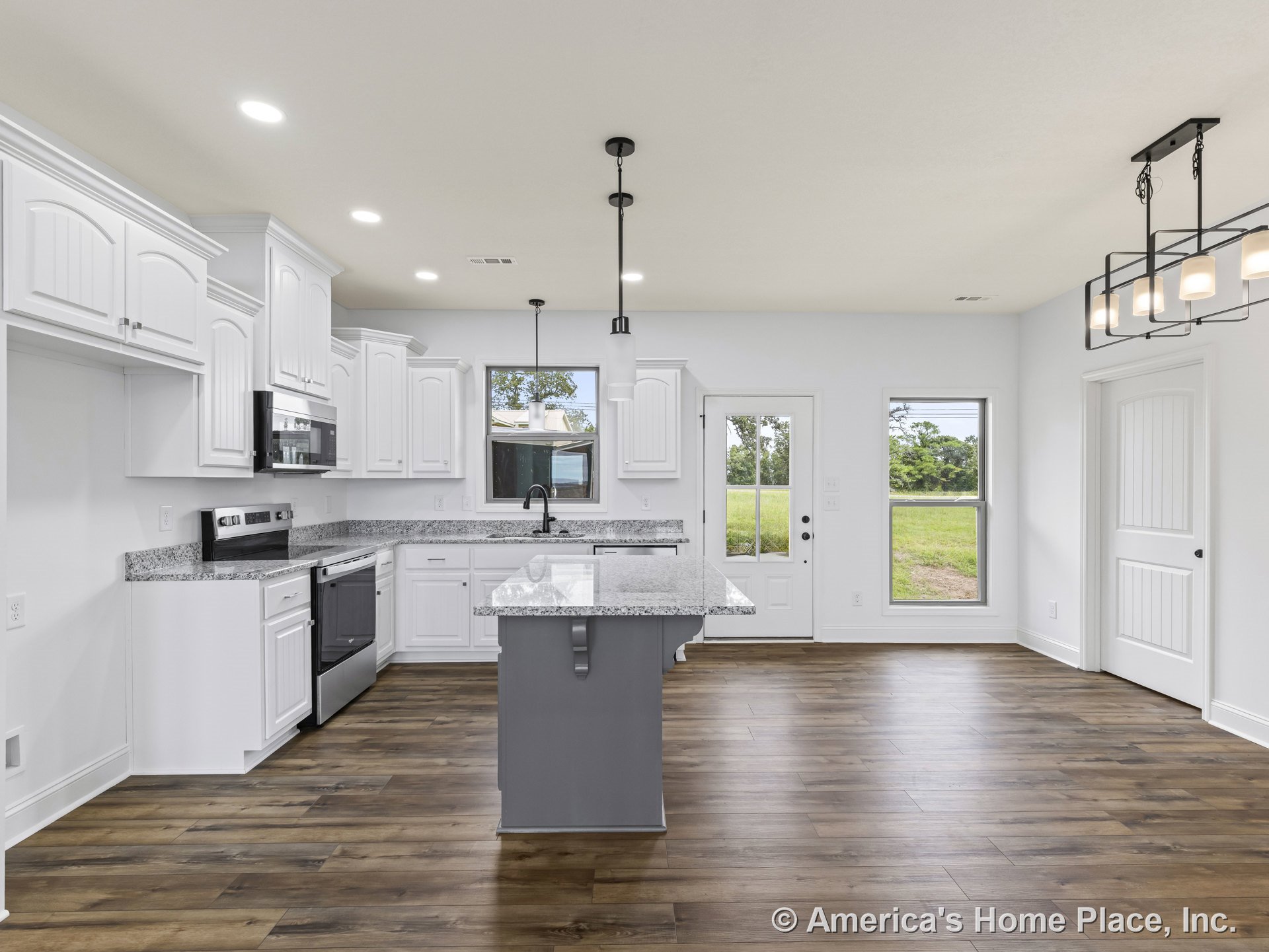 White upper and lower kitchen cabinets with granite countertops and large kitchen island, stainless steel appliances, recessed ceiling lights, pendant lighting above island