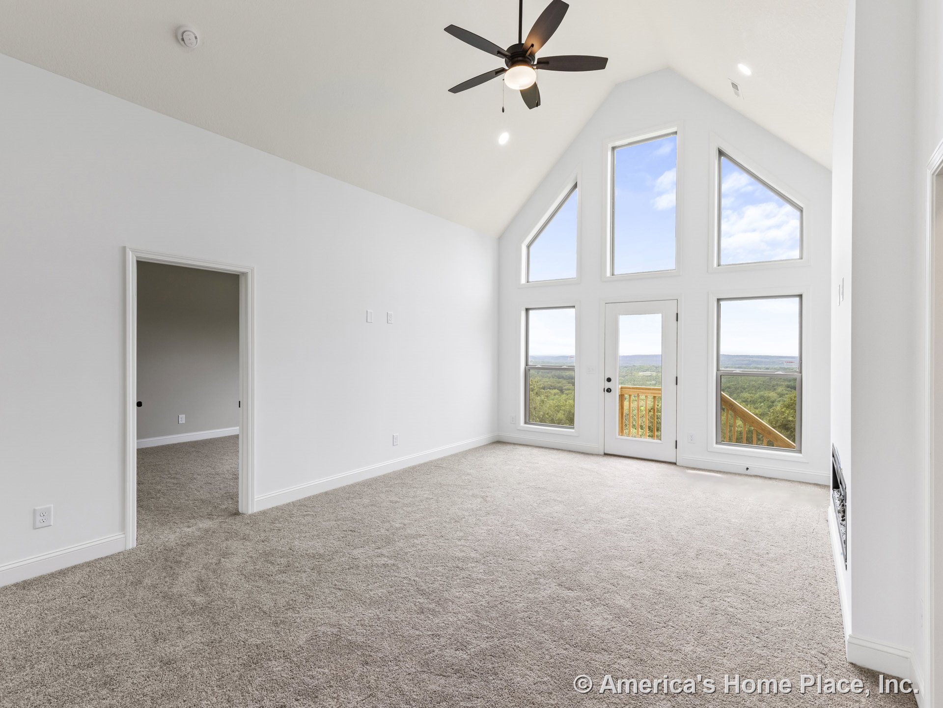 Vaulted ceiling living room with large triangular windows, glass balcony door, neutral carpet flooring, white trim and walls, ceiling fan with light, recessed lighting, and open