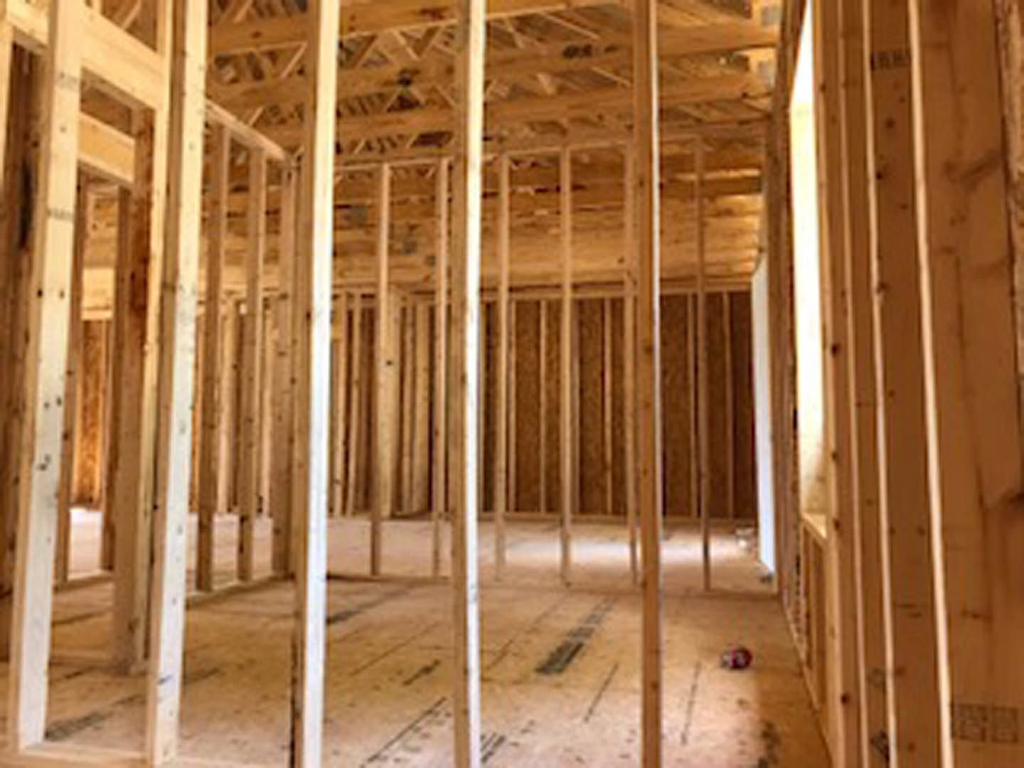 Exposed wood ceiling beams, light-colored wooden plank ceiling, large window with natural light, hardwood floor