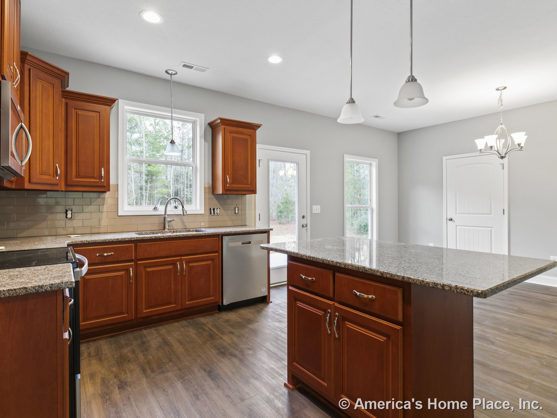 Granite kitchen island with wood cabinetry, tile backsplash, stainless steel appliances, pendant and recessed lighting, double window above sink, hardwood flooring, and open layout