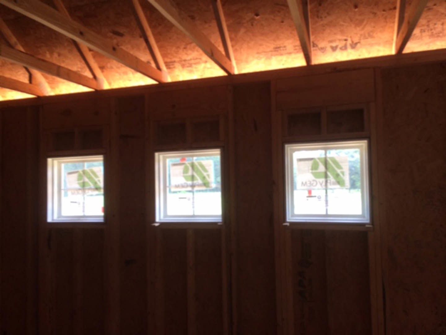 Spacious room with large windows, exposed wood ceiling beams, and neutral walls