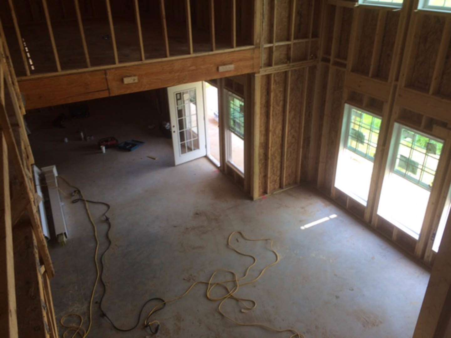 Spacious room featuring a prominent wood-paneled wall, expansive floor-to-ceiling window, light hardwood flooring, and modern trim detailing