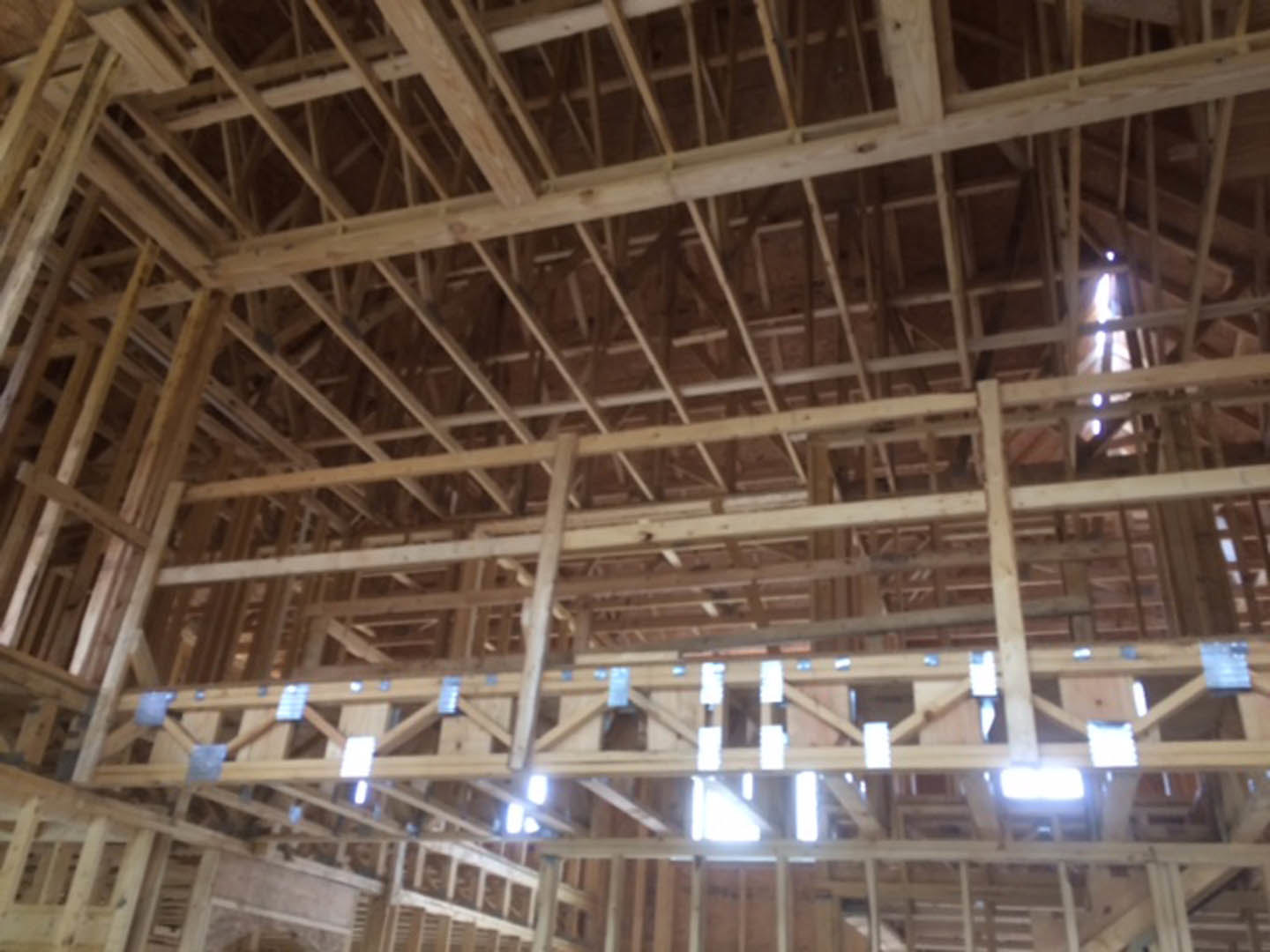 Exposed wooden ceiling beams in a modern interior with natural light filtering through, highlighting wood grain and architectural structure