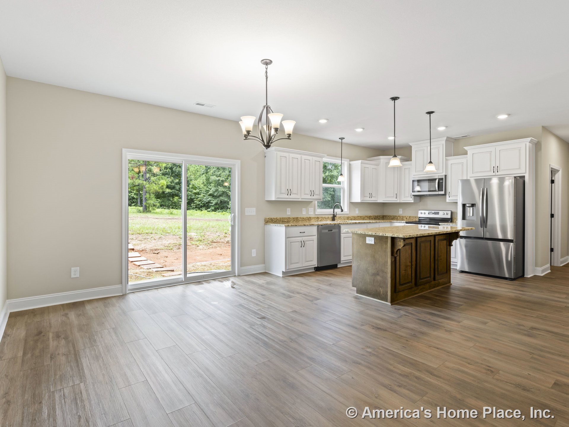 Open kitchen with white upper and lower cabinets, granite countertops, stainless steel refrigerator and built-in appliances, wood-look flooring, central island, pendant and