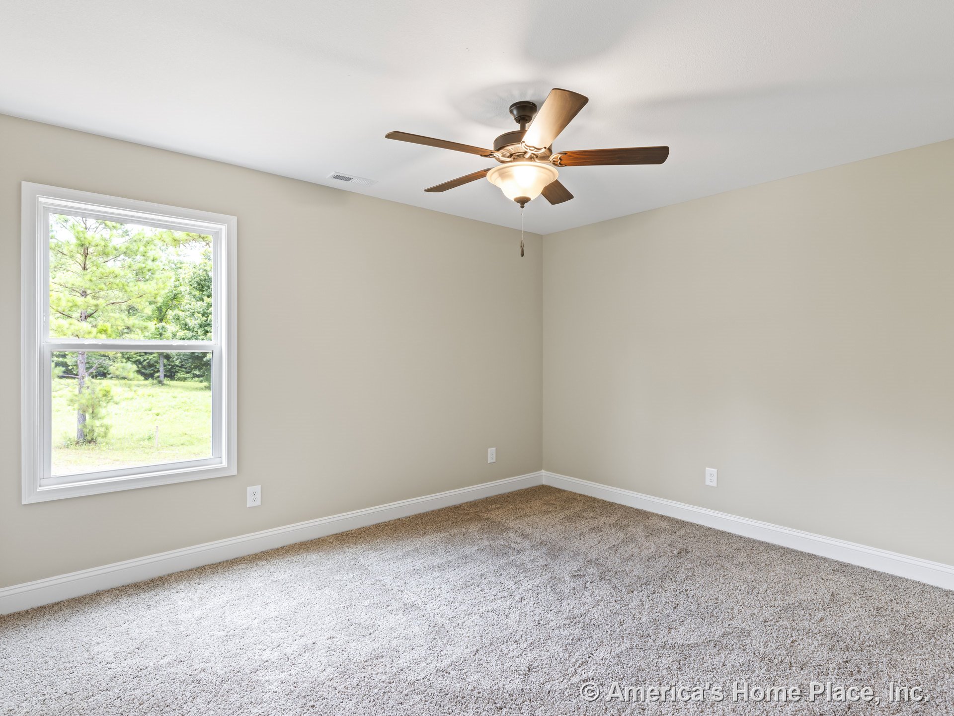 Beige carpet flooring, neutral painted walls, white baseboards, ceiling fan with integrated light fixture, large single window with white trim allowing natural light