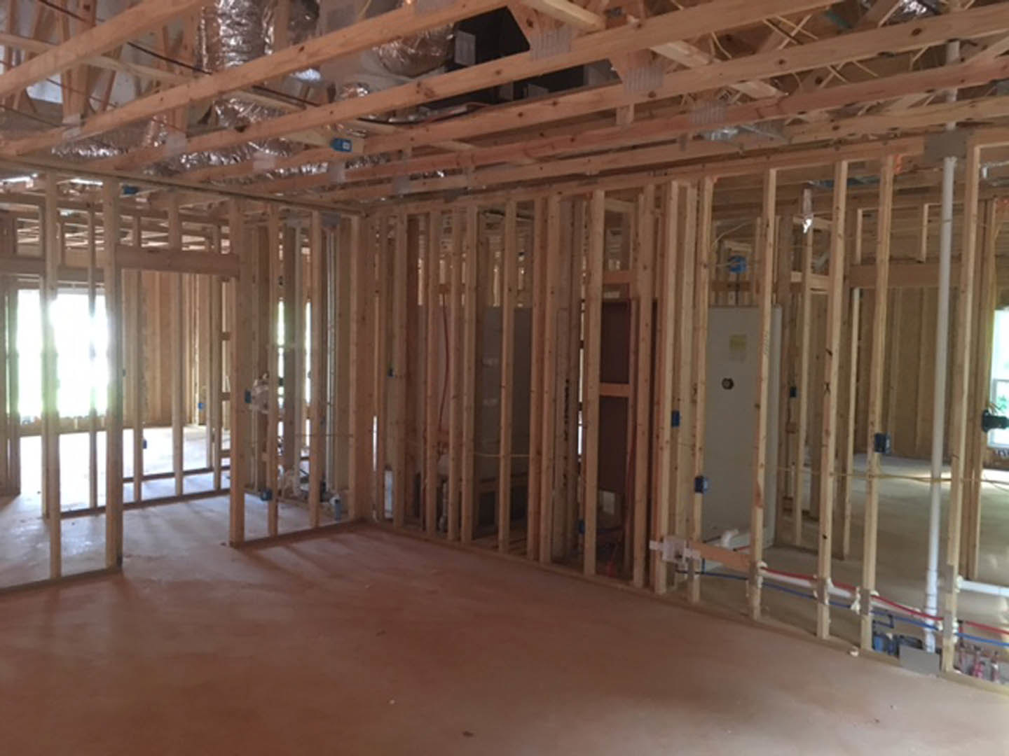 Wood plank ceiling with exposed beams, recessed vent, white walls, and a white door with a round security camera