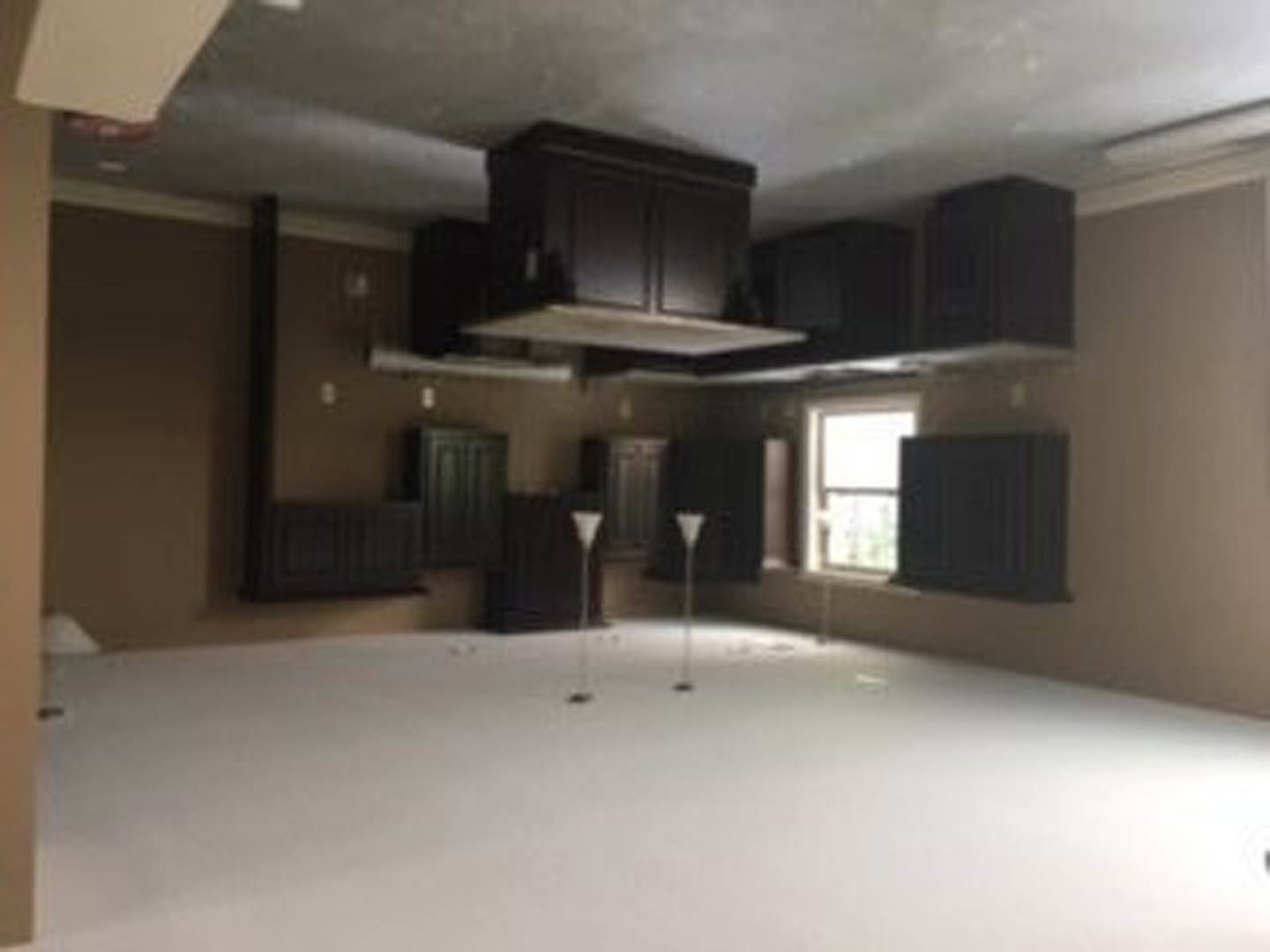 White tile floor with matte black kitchen cabinets, white walls, and recessed ceiling lighting