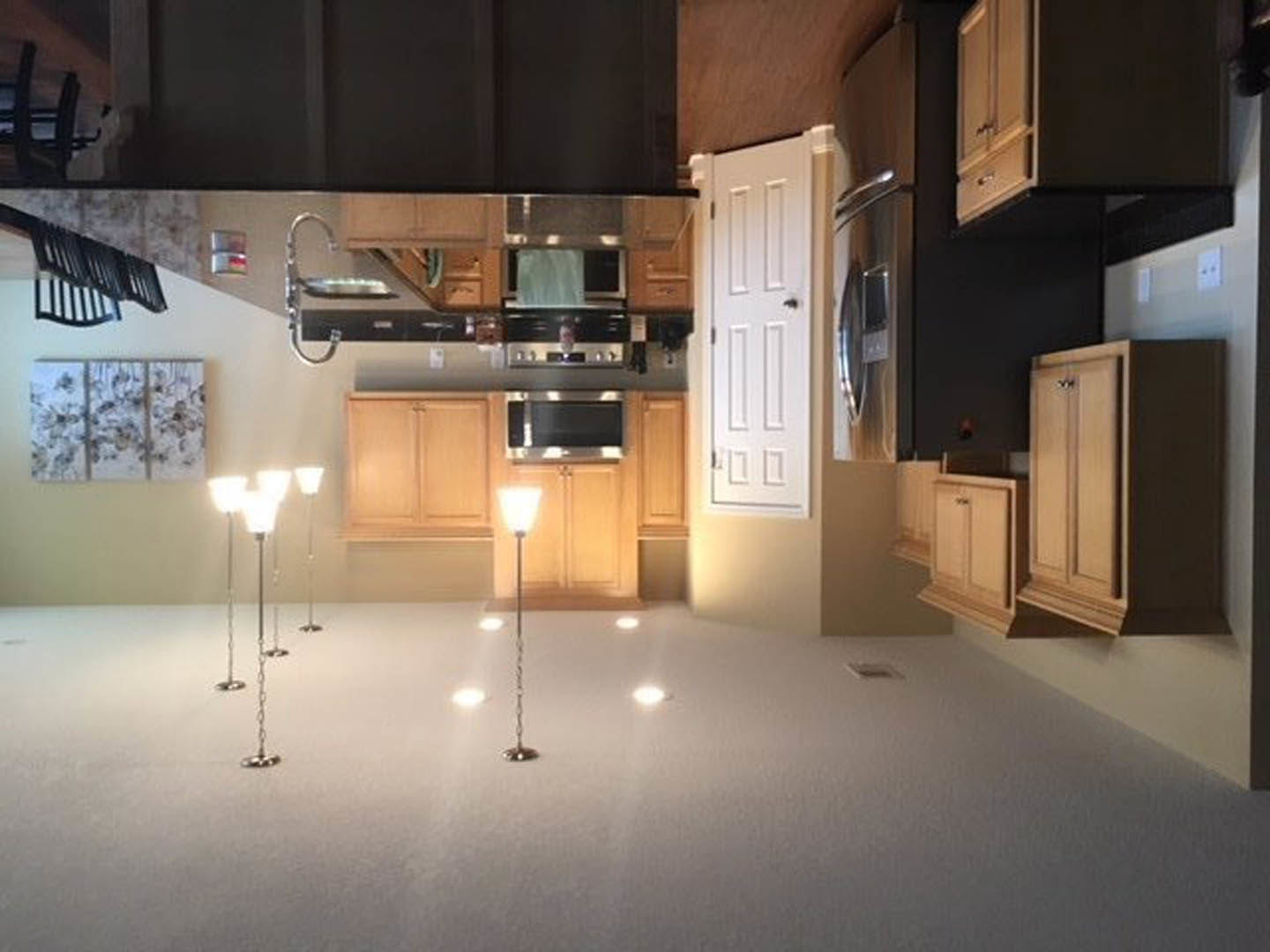 Modern kitchen with white cabinetry, stainless steel sink and stove, quartz countertops, track lighting, and a stainless steel refrigerator