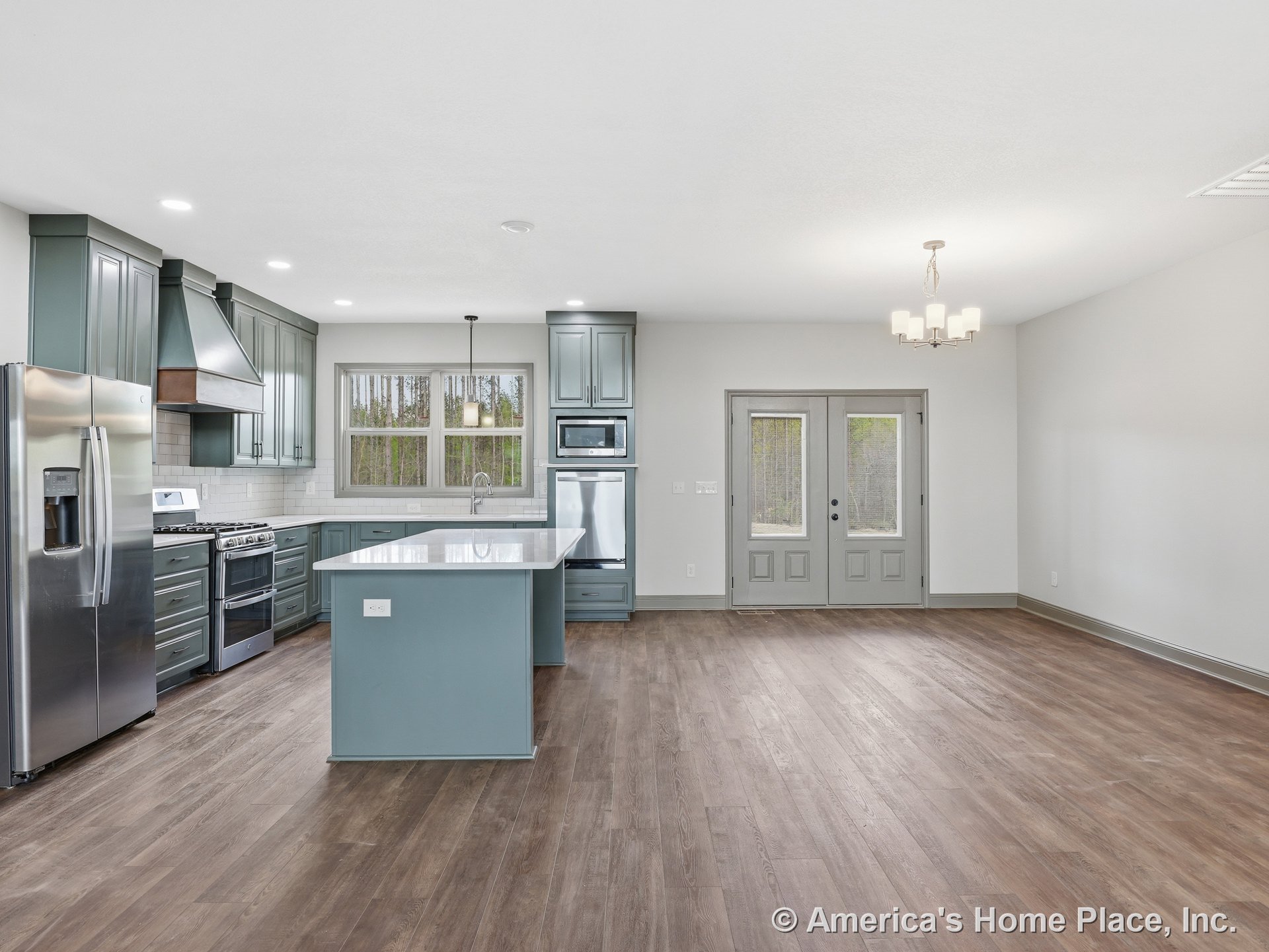 Blue shaker kitchen cabinets with stainless steel refrigerator, quartz island, wood-look flooring, subway tile backsplash, built-in ceiling lights, pendant light above island
