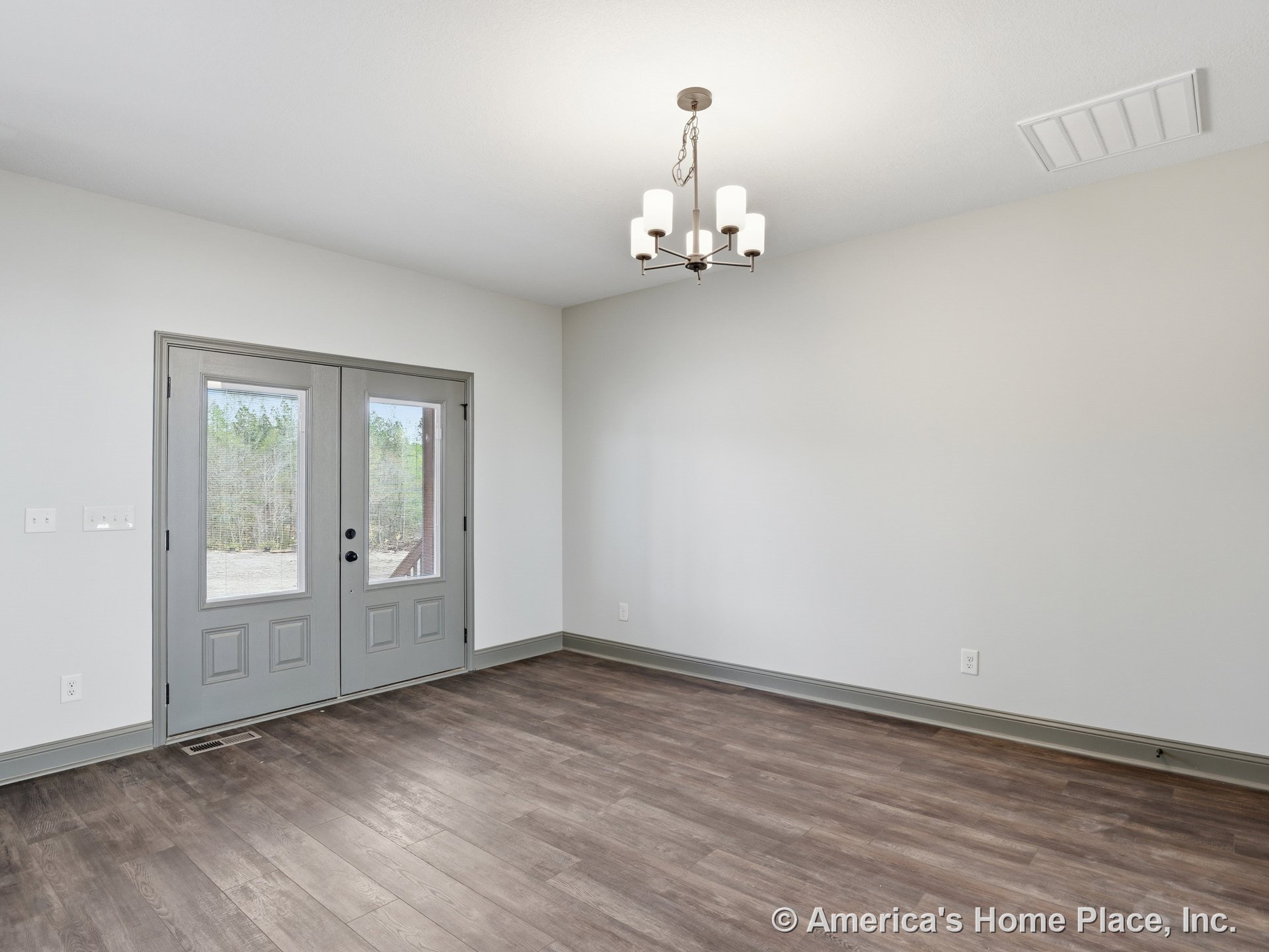 Double glass entry doors open to a foyer with wood-look plank flooring, modern chandelier, gray trim and baseboards, neutral wall color, and a floor vent.