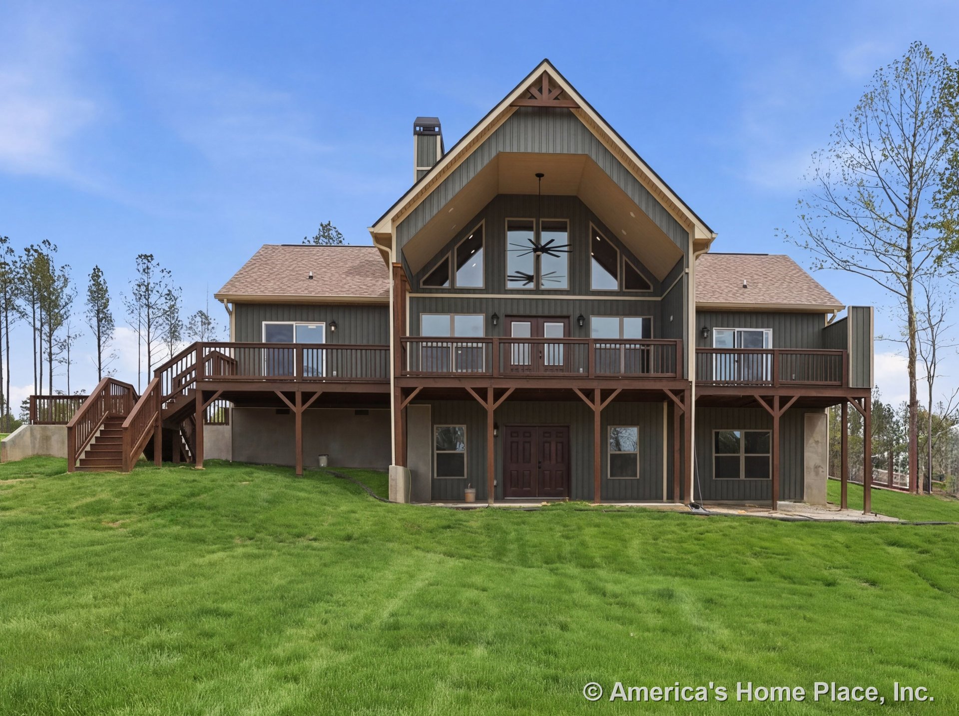 Two-story exterior with vertical wood siding, expansive covered upper balcony, prominent gable rooflines, multiple windows, double entry doors, exterior staircase, decorative trim