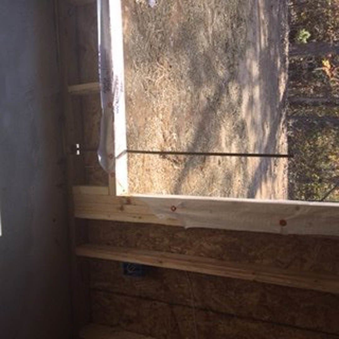 Bathroom with wood-framed window, white walls, and view of trees outside