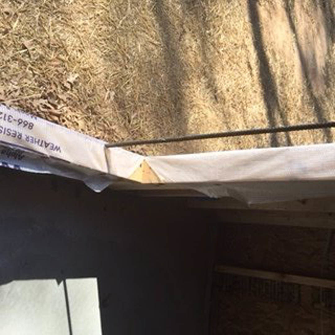 White sheet draped over metal rod at outdoor residential construction site with exposed ground
