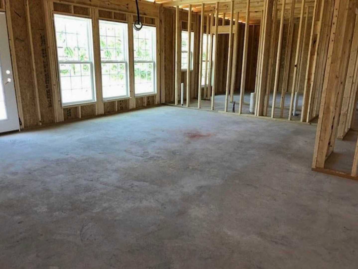Concrete floor with wood plank ceiling, row of square windows along one wall, natural light highlighting minimalist finishes