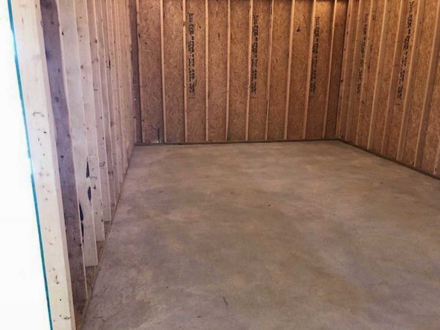 Concrete floor with natural wood plank walls in a modern residential interior