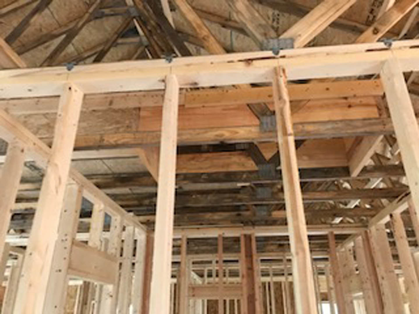 Exposed wooden beams and planks forming the interior frame of a house under construction