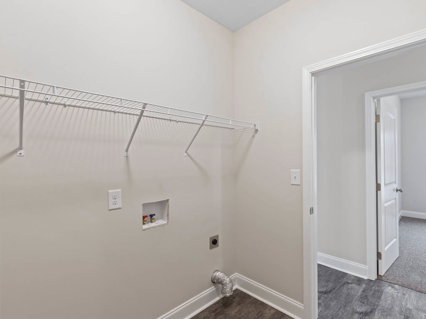 White plaster wall with built-in white shelf, rectangular hole cutout, and adjacent white door in a modern interior room.