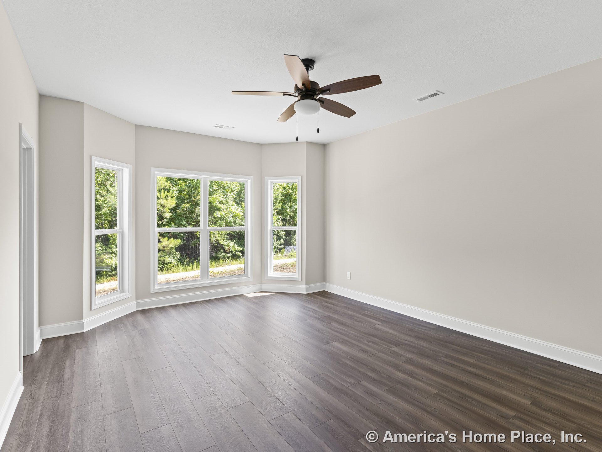 Large bay window with multiple panels, wood-look plank flooring, neutral wall paint, white baseboard trim, ceiling fan with light, rectangular room layout, abundant natural light.