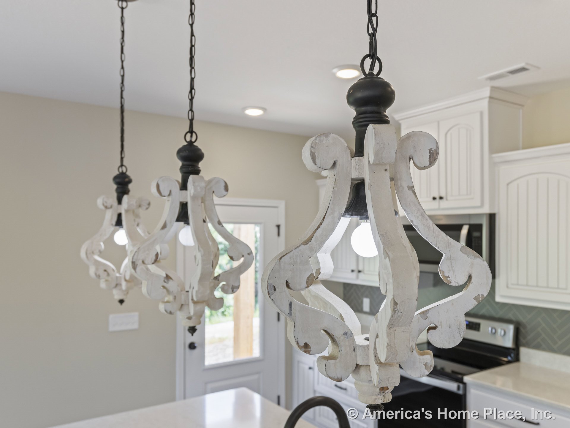 Distressed wood pendant lights suspended above a kitchen island with white cabinetry, quartz countertops, herringbone tile backsplash, stainless steel oven, and recessed ceiling