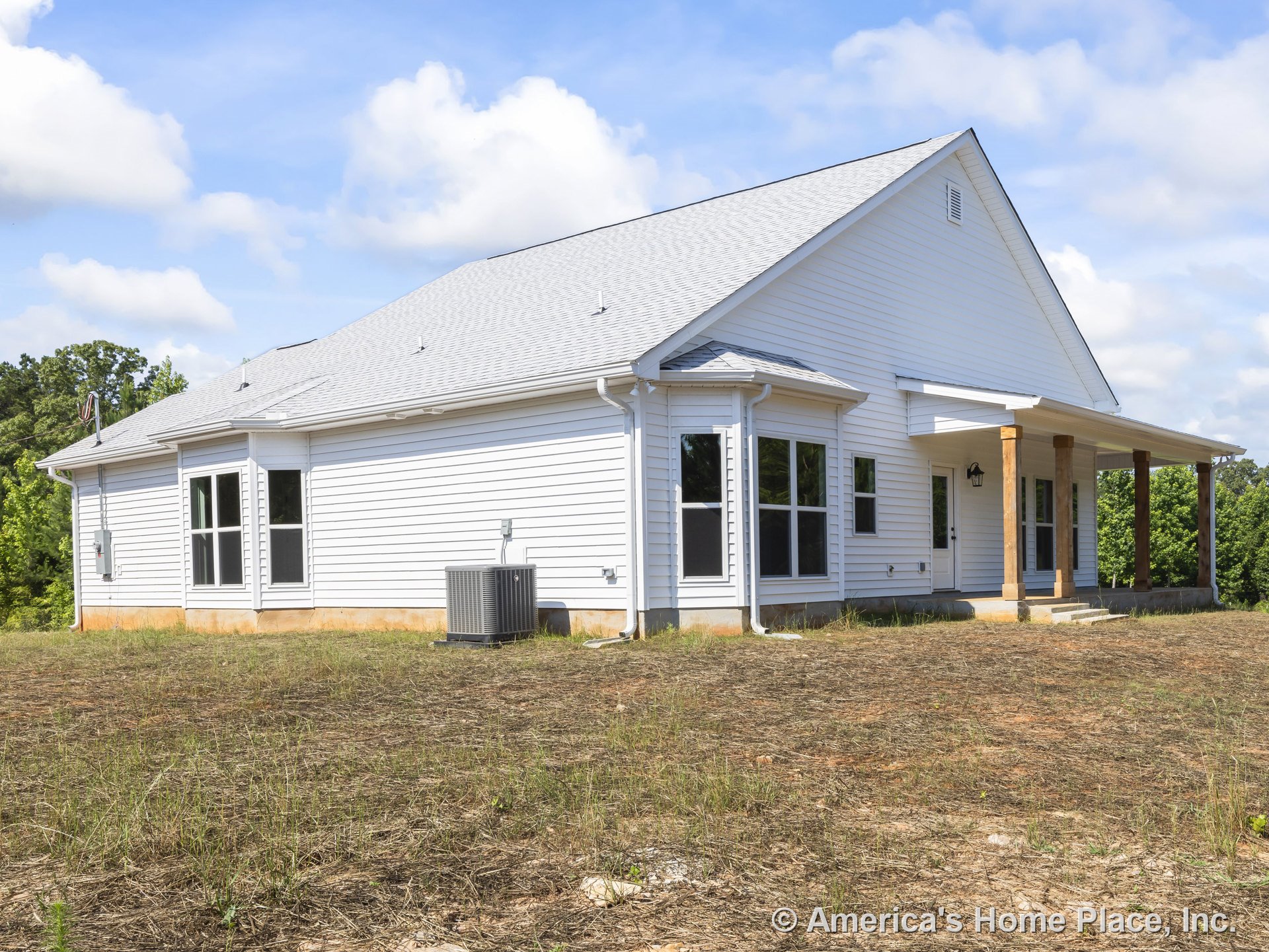 White vinyl siding exterior with gable roof, multiple large windows, covered front porch supported by wooden columns, exterior lighting fixture, central air conditioning unit
