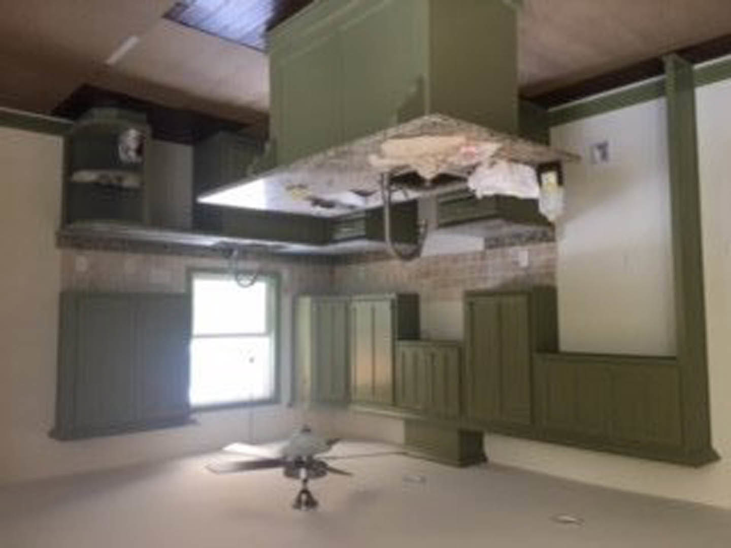 Modern kitchen with white cabinetry, stainless steel appliances, ceiling fan, and neutral walls