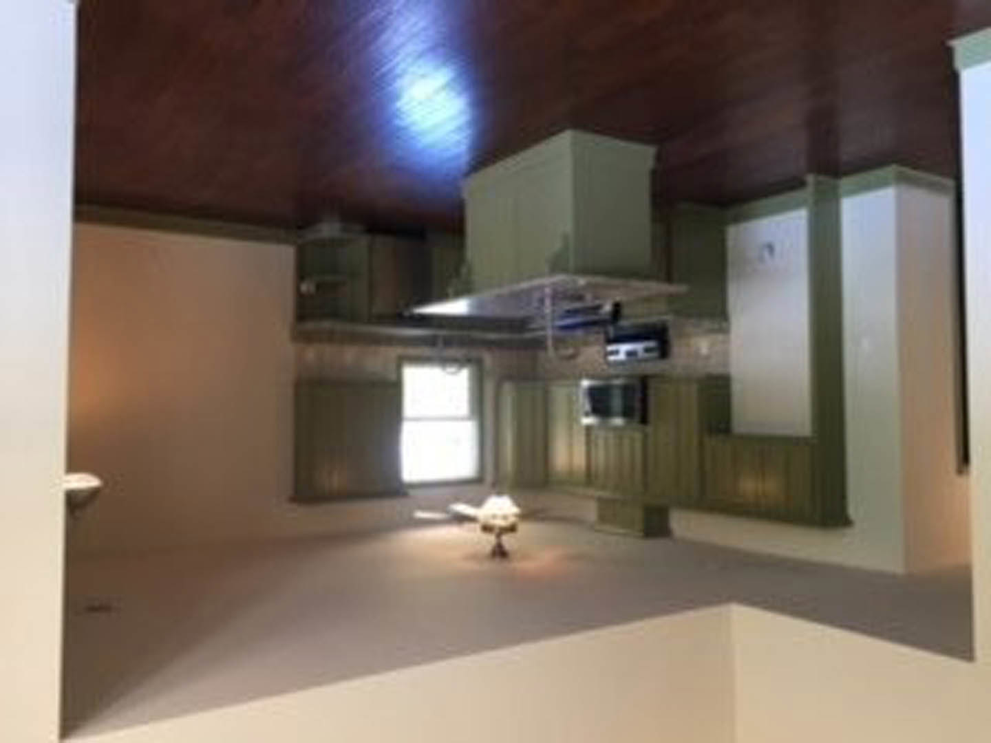 Open-concept kitchen with wood plank ceiling, stainless steel stove, white cabinets, and recessed lighting