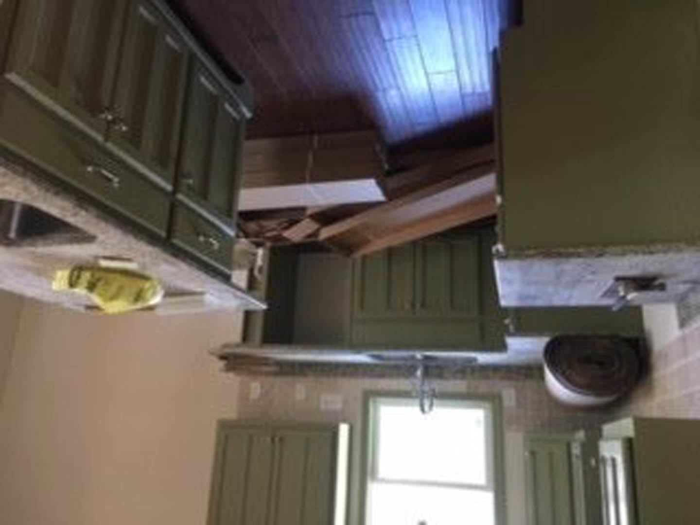 Kitchen with matte green cabinets, stainless steel sink, white countertops, brushed metal handles, and a modern range hood under recessed lighting