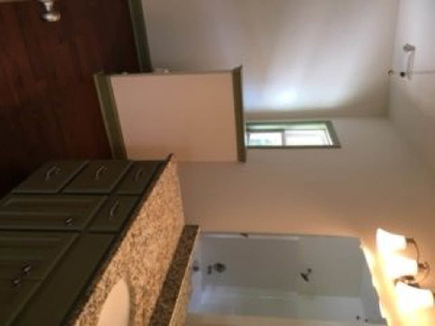 Modern bathroom featuring a rectangular sink with chrome faucet, wide mirror above light wood cabinetry, white countertop, and neutral wall finishes