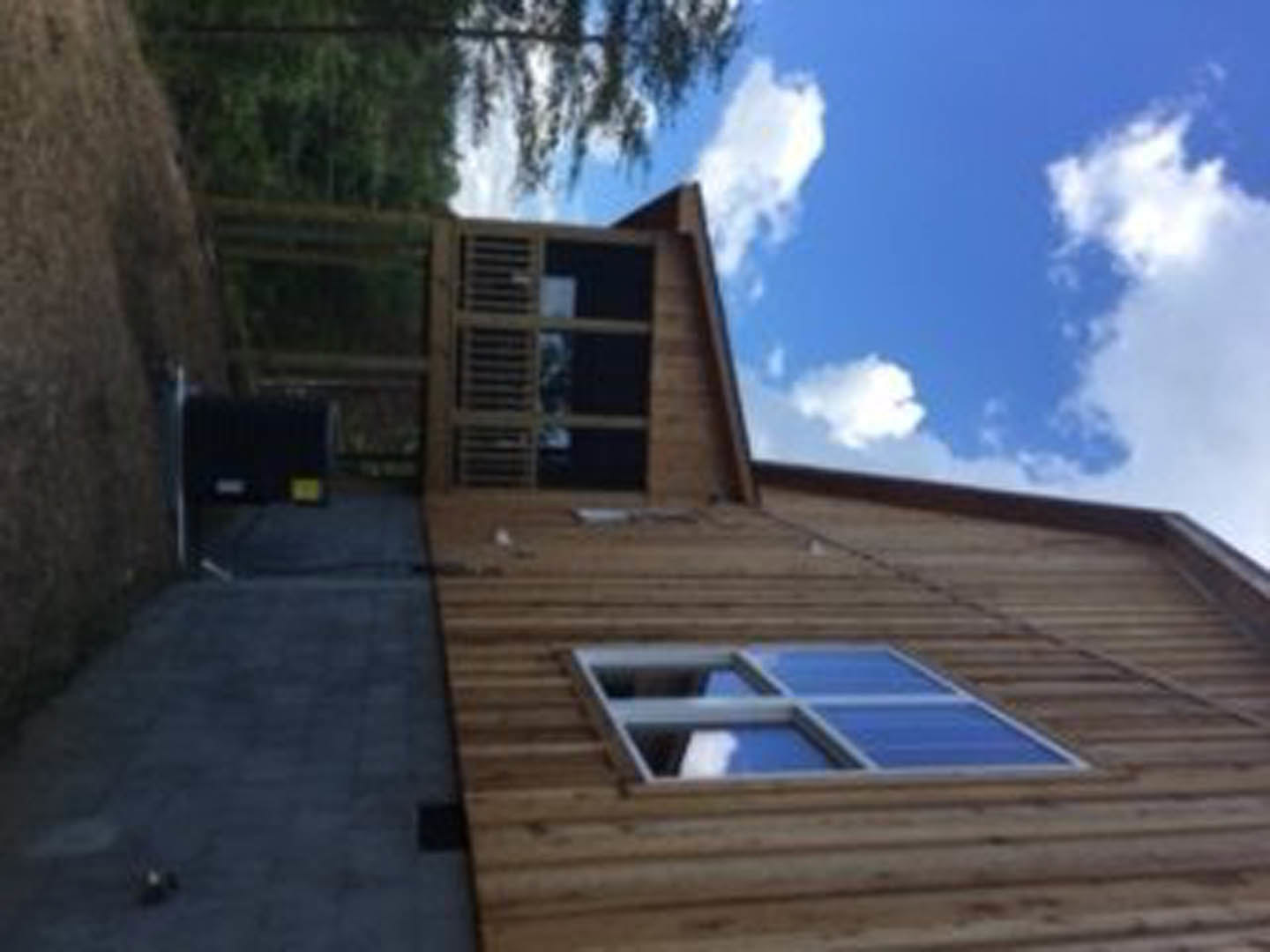 Two-story house with covered front porch, white siding, brick walkway leading to entrance, trimmed shrubs, and solar panels on roof