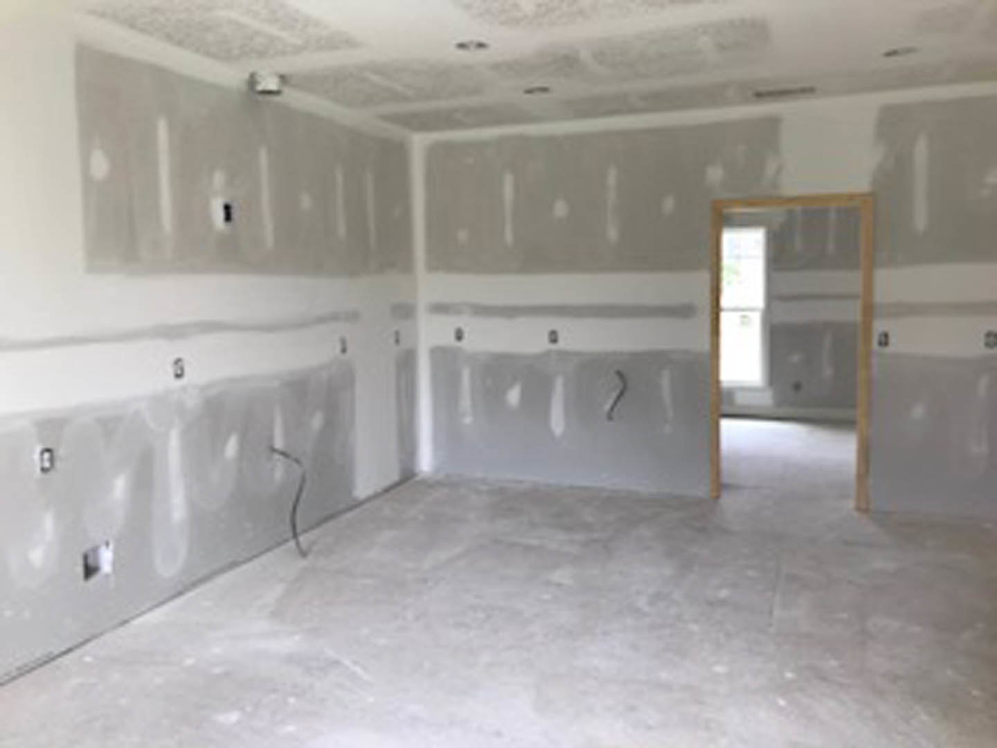 White walls, light-colored floor, simple door, and ceiling in an unfurnished room