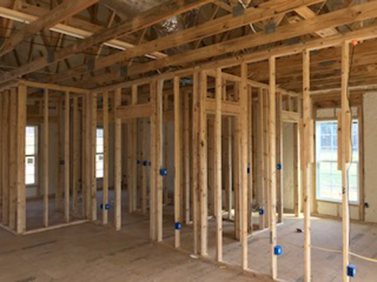 Living room with exposed wood ceiling beams, large window, light-colored walls, and hardwood flooring