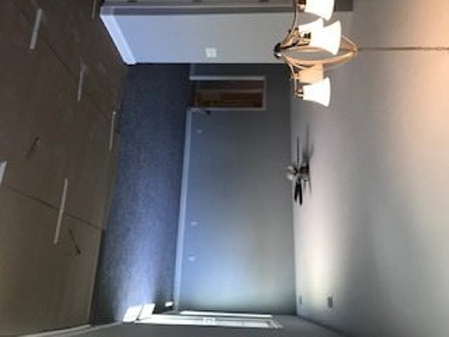 Open-concept room with plaster walls, ceiling-mounted light fixture, white sink, and shower area.