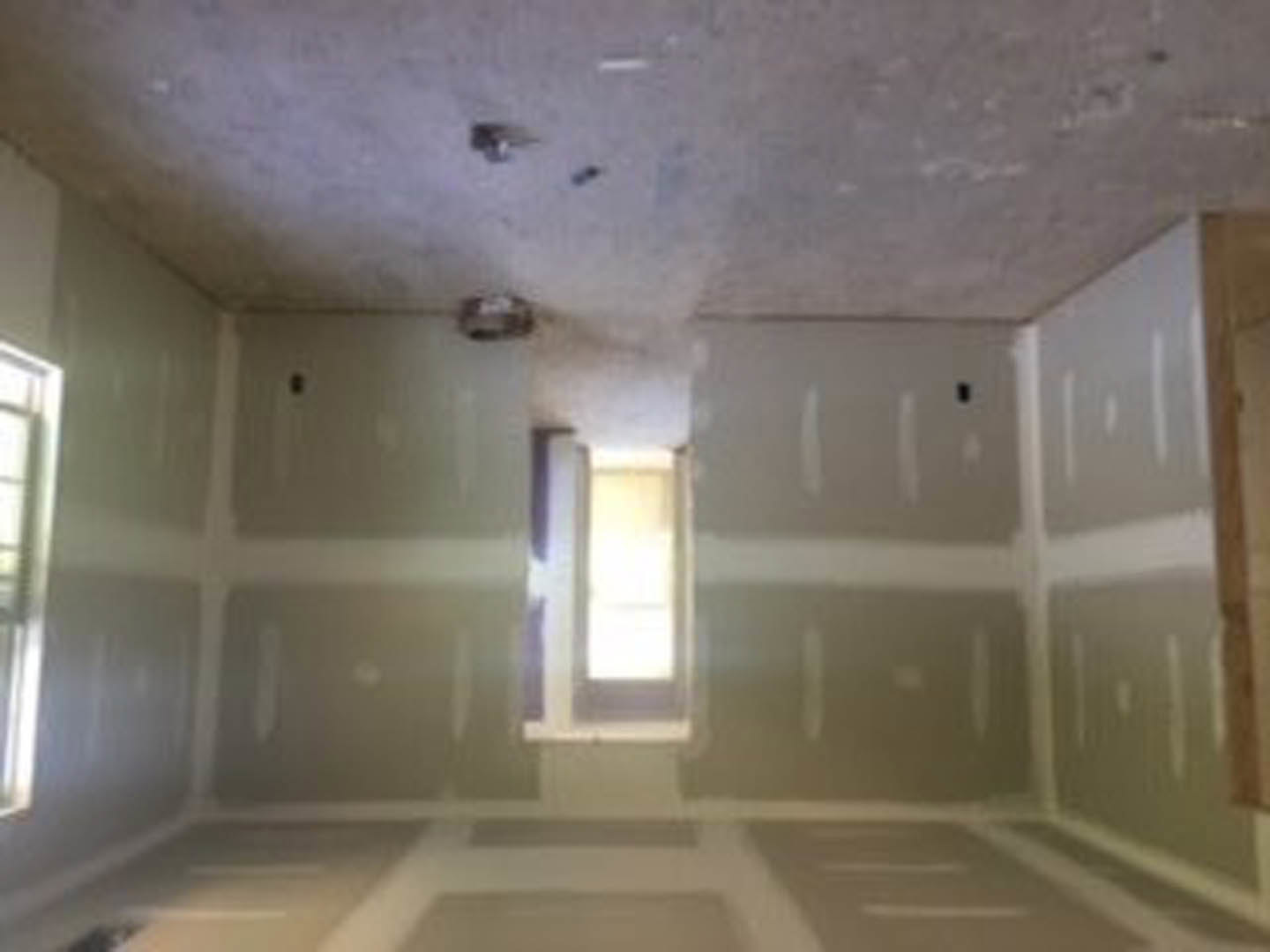 White-walled room with tile flooring, large window, plaster ceiling, and decorative molding.