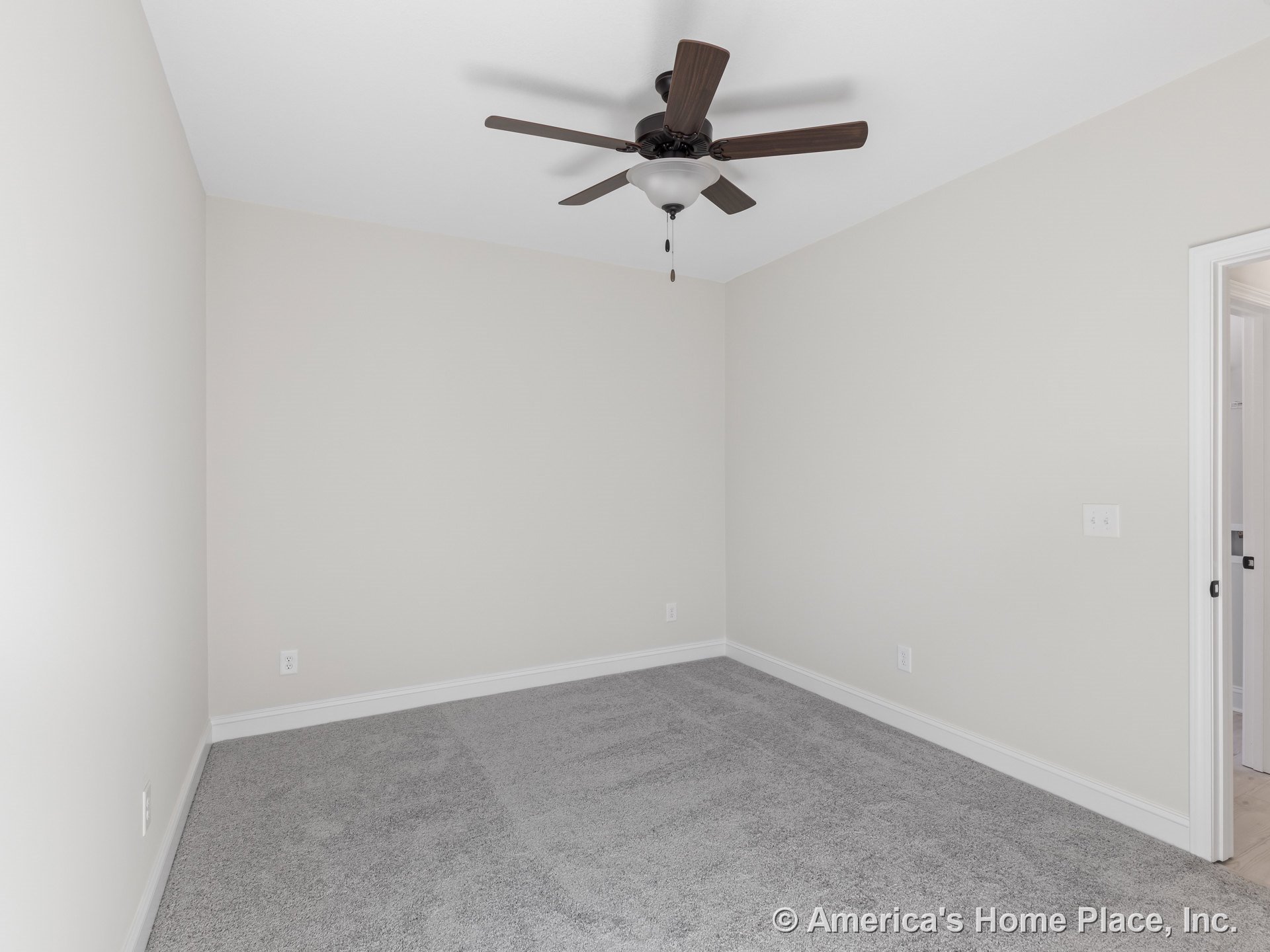 Bedroom with light gray carpet flooring, white baseboards, neutral wall color, ceiling fan with integrated light, flush ceiling, doorway to adjacent room, and modern wall outlet.