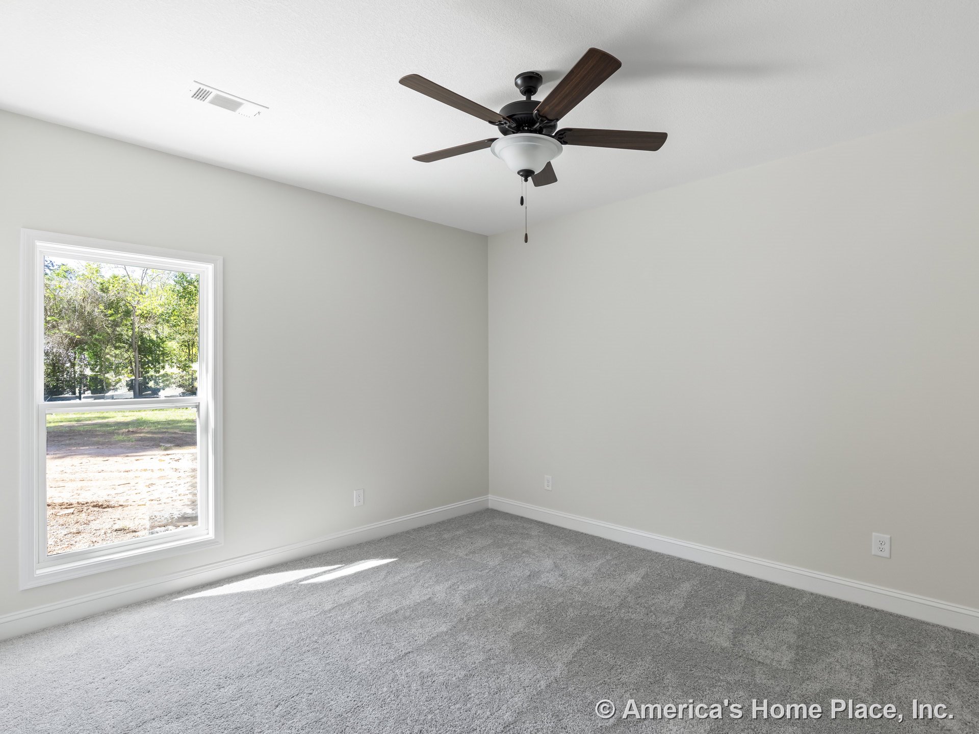Bedroom with light gray carpet flooring, large window framed in white trim, ceiling fan with integrated light fixture, neutral painted walls, white baseboards, and ceiling vent.