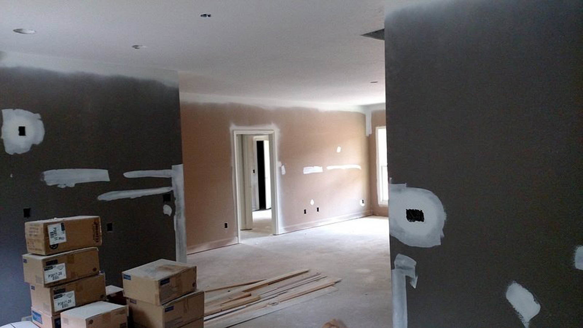 White-painted walls and ceiling, light wood flooring, single door with modern trim, minimalist interior layout with few partitions