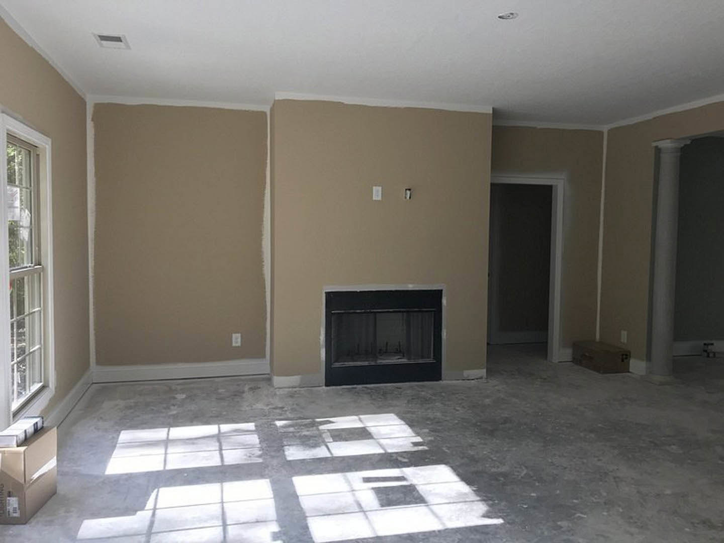 Living room with white tile floor, plaster walls, modern fireplace, large window, and wooden door