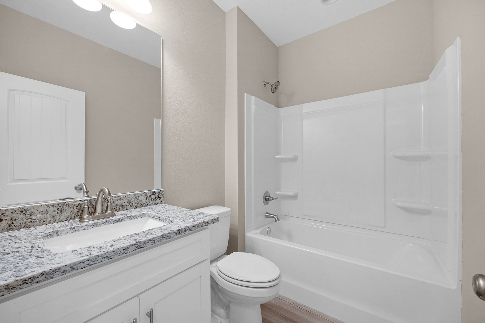 White porcelain sink with chrome faucet set in a tiled bathroom, adjacent to a closed white toilet and neutral wall tiles.