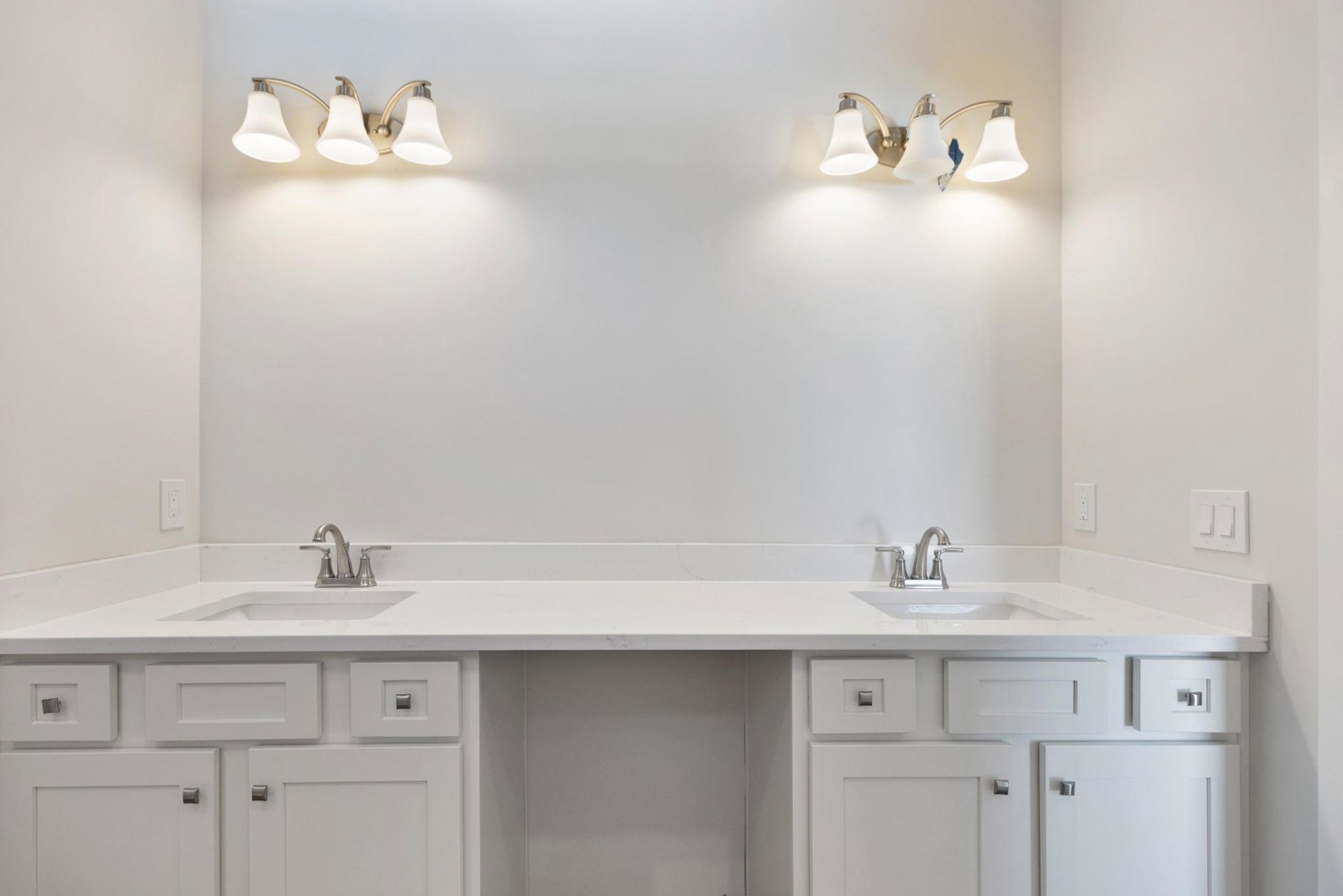 Bathroom with white shaker cabinets, square metal knobs, white countertops, dual sinks, chrome faucets, and light gray tile backsplash