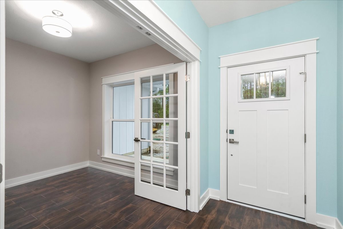 Room with white paneled doors, large window, and light wood laminate flooring