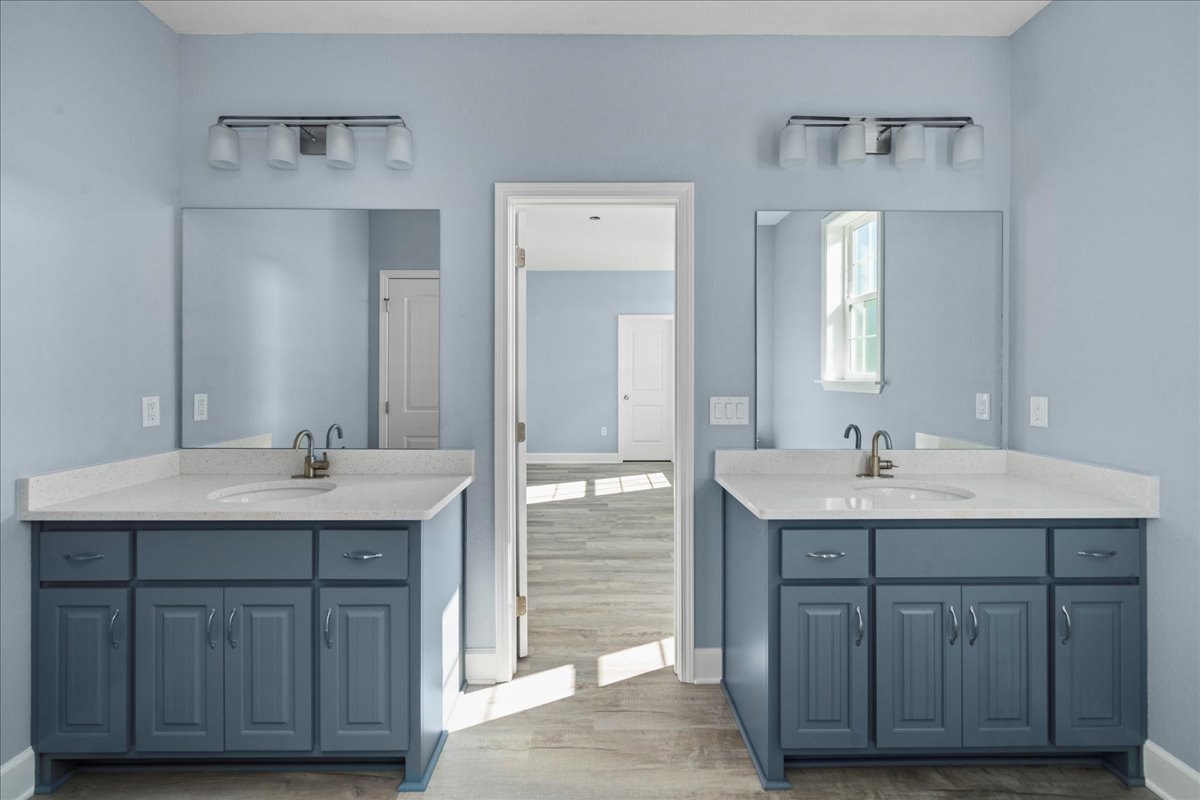 Bathroom with blue shaker cabinets, white quartz countertops, undermount sink, black metal light fixture with white shades, white framed window, and white tile backsplash