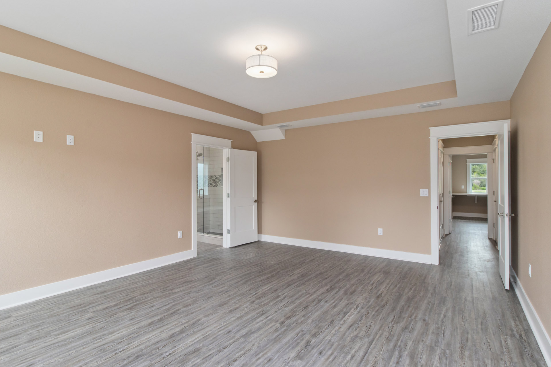 Wood floor room featuring a white glass-paneled door, hallway window, ceiling light fixture with white shade, wall vent, and plaster walls with molding.