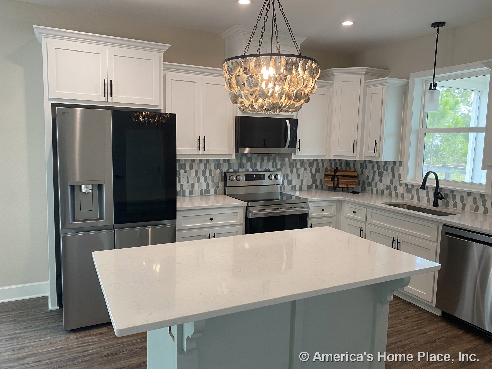 White shaker cabinets and quartz island countertop with geometric tile backsplash, stainless steel appliances, pendant and chandelier lighting, large window above sink, and wood