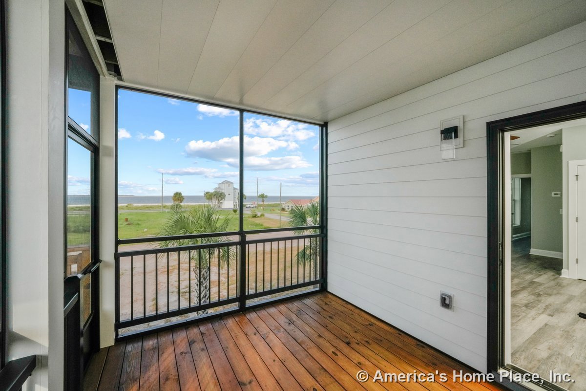 Screened porch with wood plank flooring, horizontal lap siding, ceiling panels, metal railing, exterior wall light, door, window, and trim detailing.