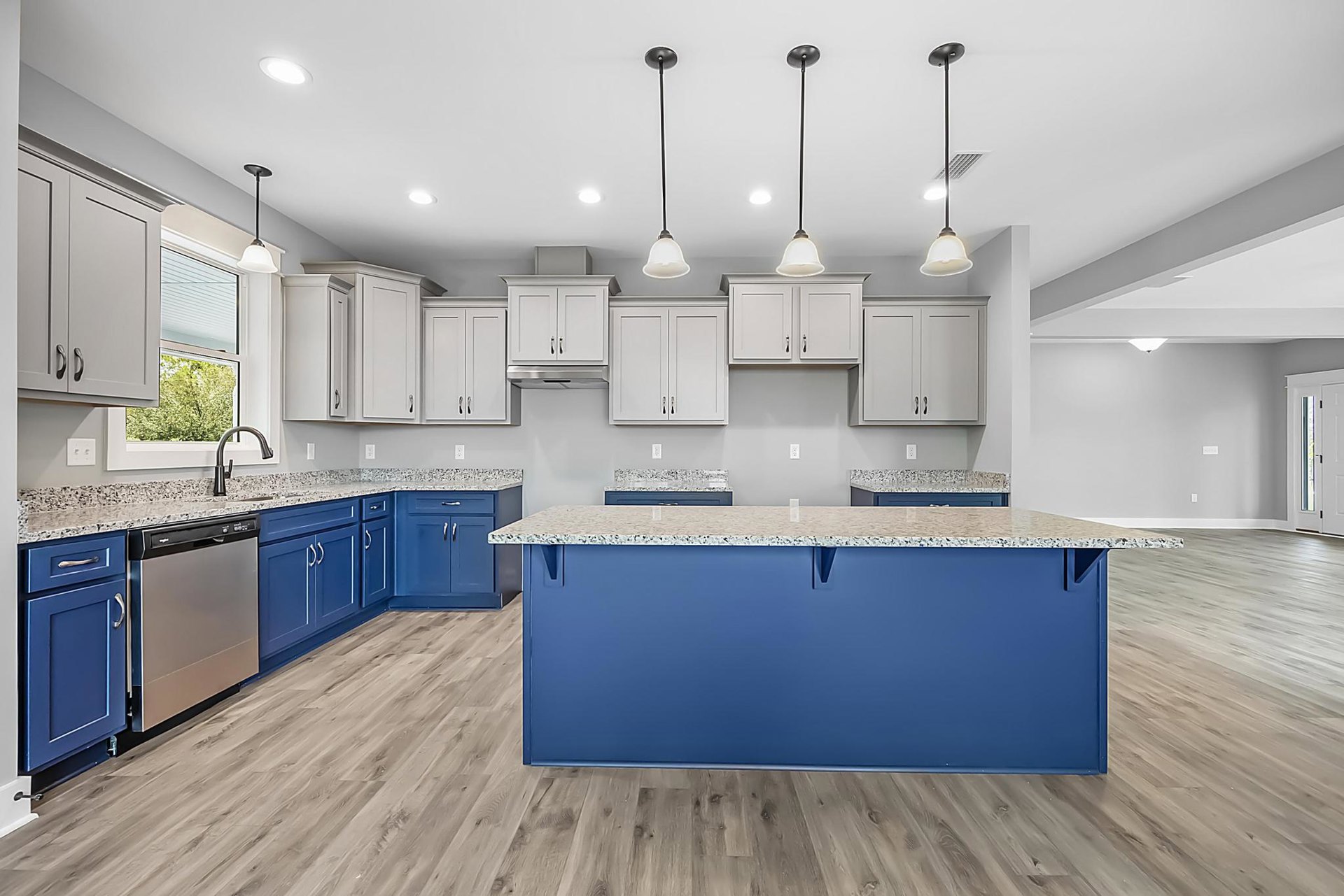 Blue and white kitchen cabinets, blue countertop with white surface, black pole light fixture, stainless steel appliance, white cabinets with black handles, vent and street light